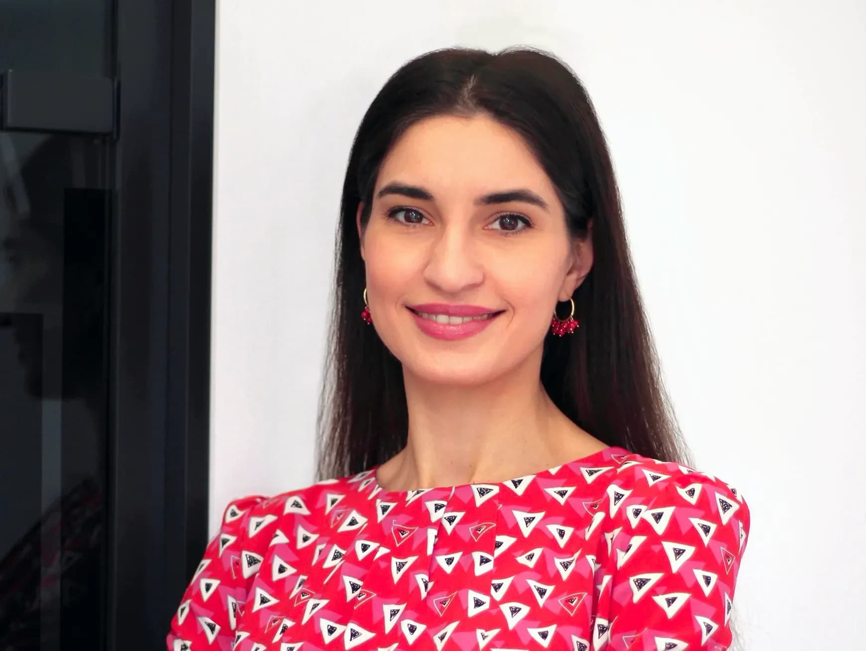 Жінка з довгим чорнявим волоссям у яскравій червоній сорочці