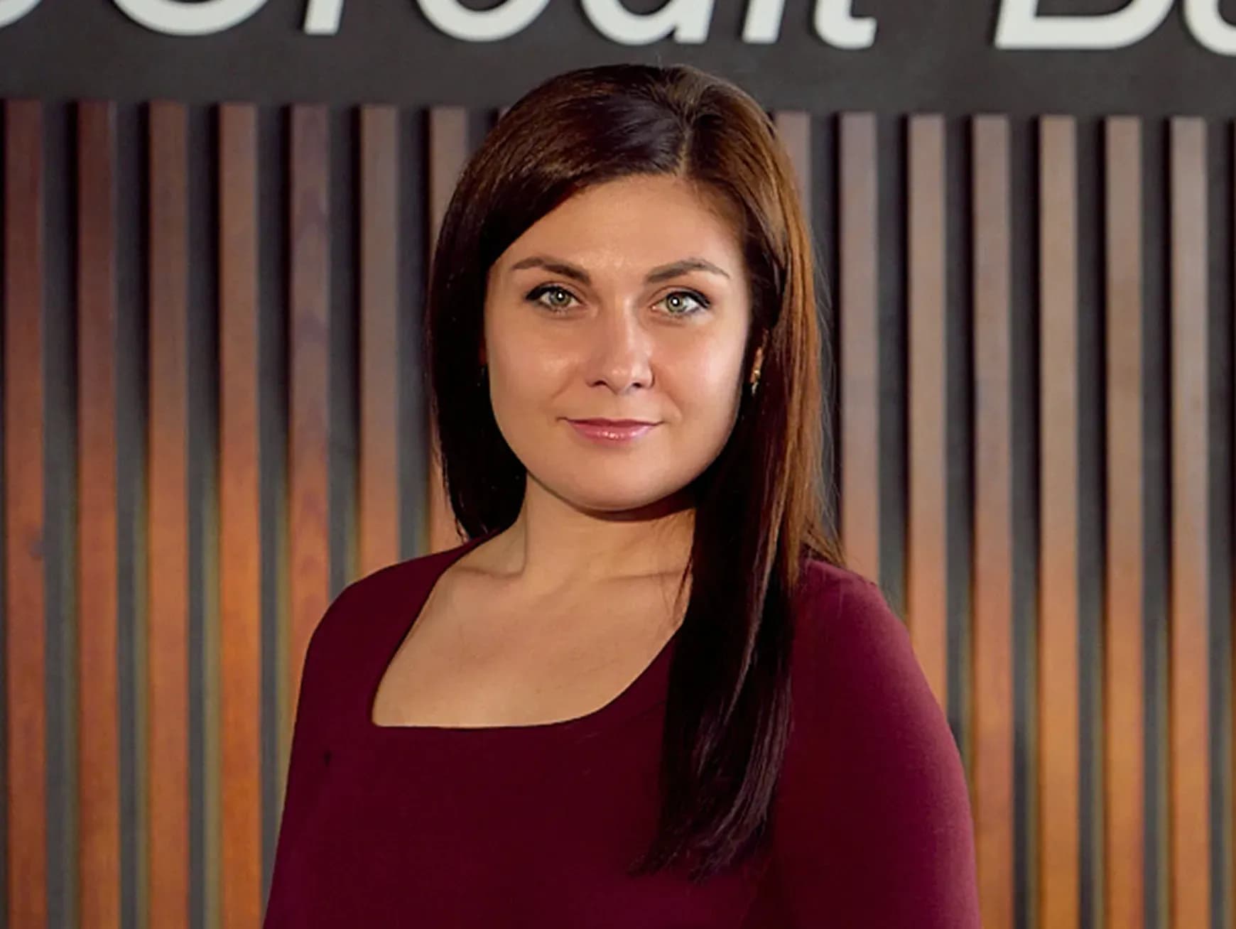 Жінка з каштановим волоссям у вишневій кофті