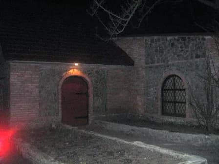 Освітлений цегляний фасад з дерев'яними дверима