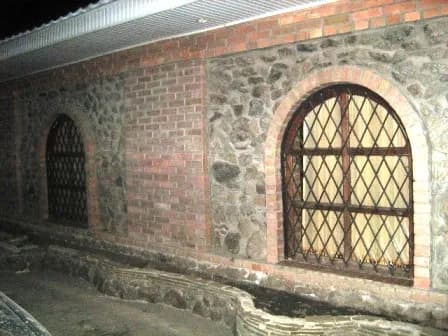 Довгий ряд аркових вікон уздовж цегляної стіни