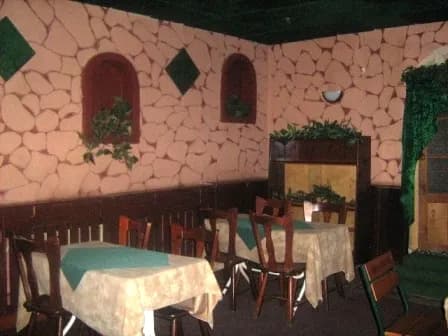 Зал із кам’яною стіною, декоративними вставками та накритими столами