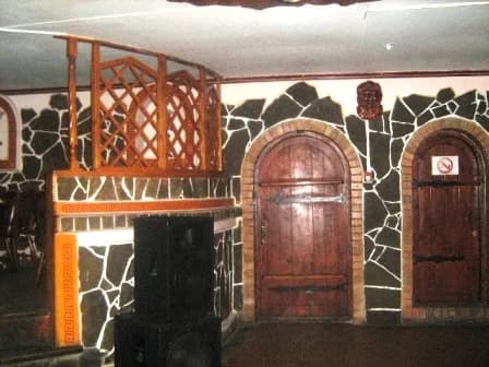 Декоративна дерев’яна арка та кам’яна стіна з центральними дверима