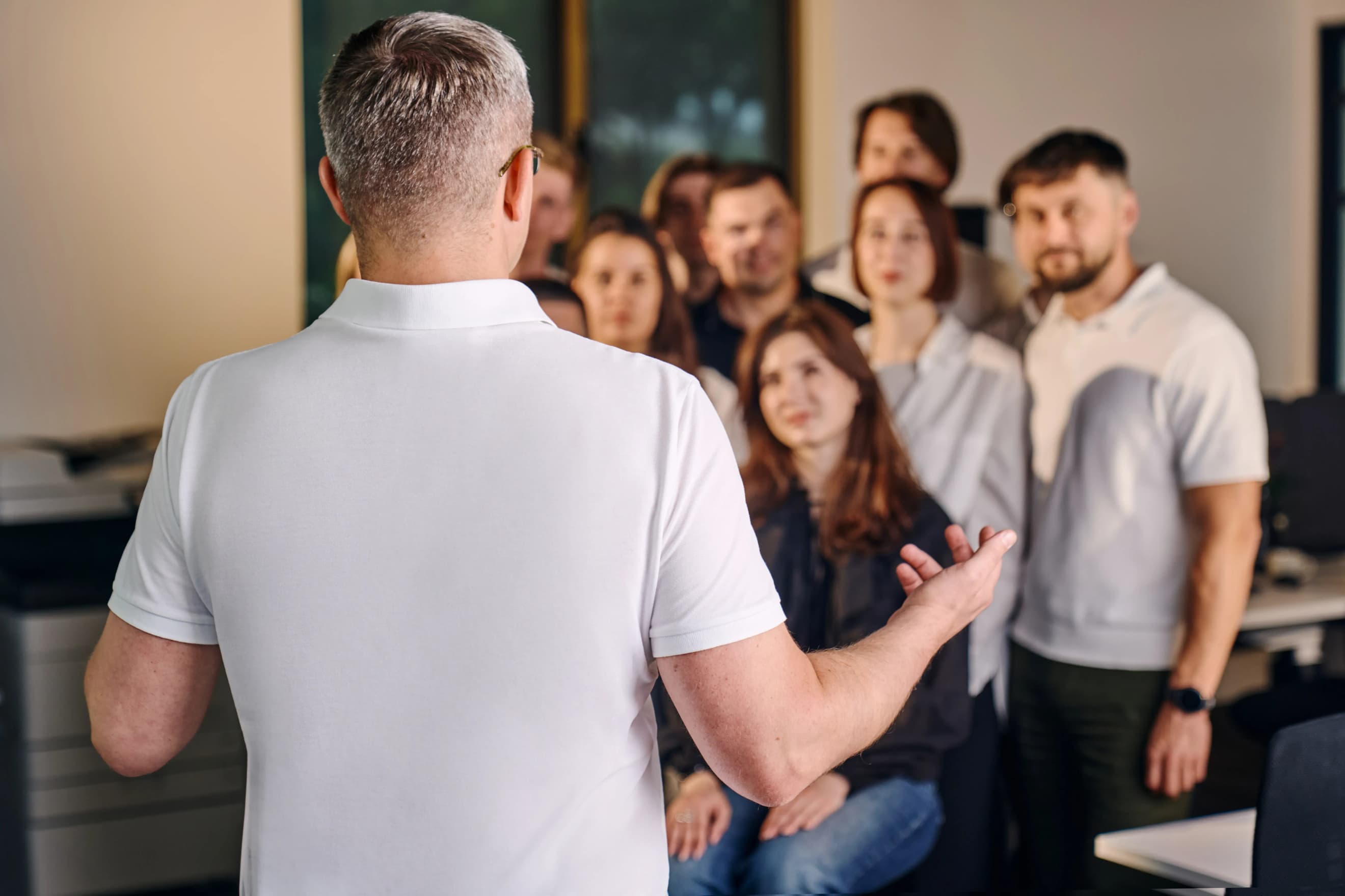 Чоловік звертається до групи людей під час робочої зустрічі в офісі