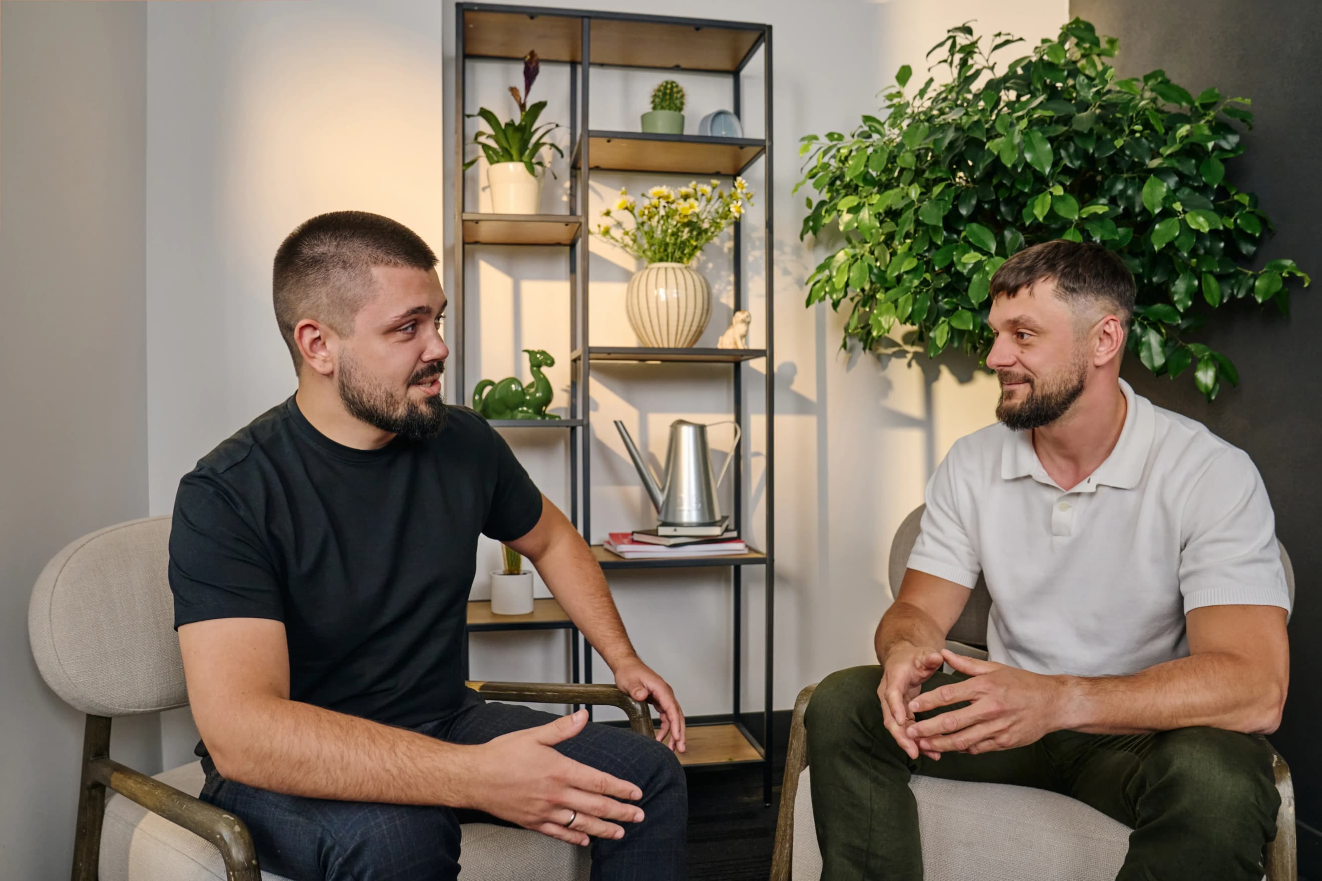 Два чоловіки сидять на стільцях і спілкуються в офісному просторі 