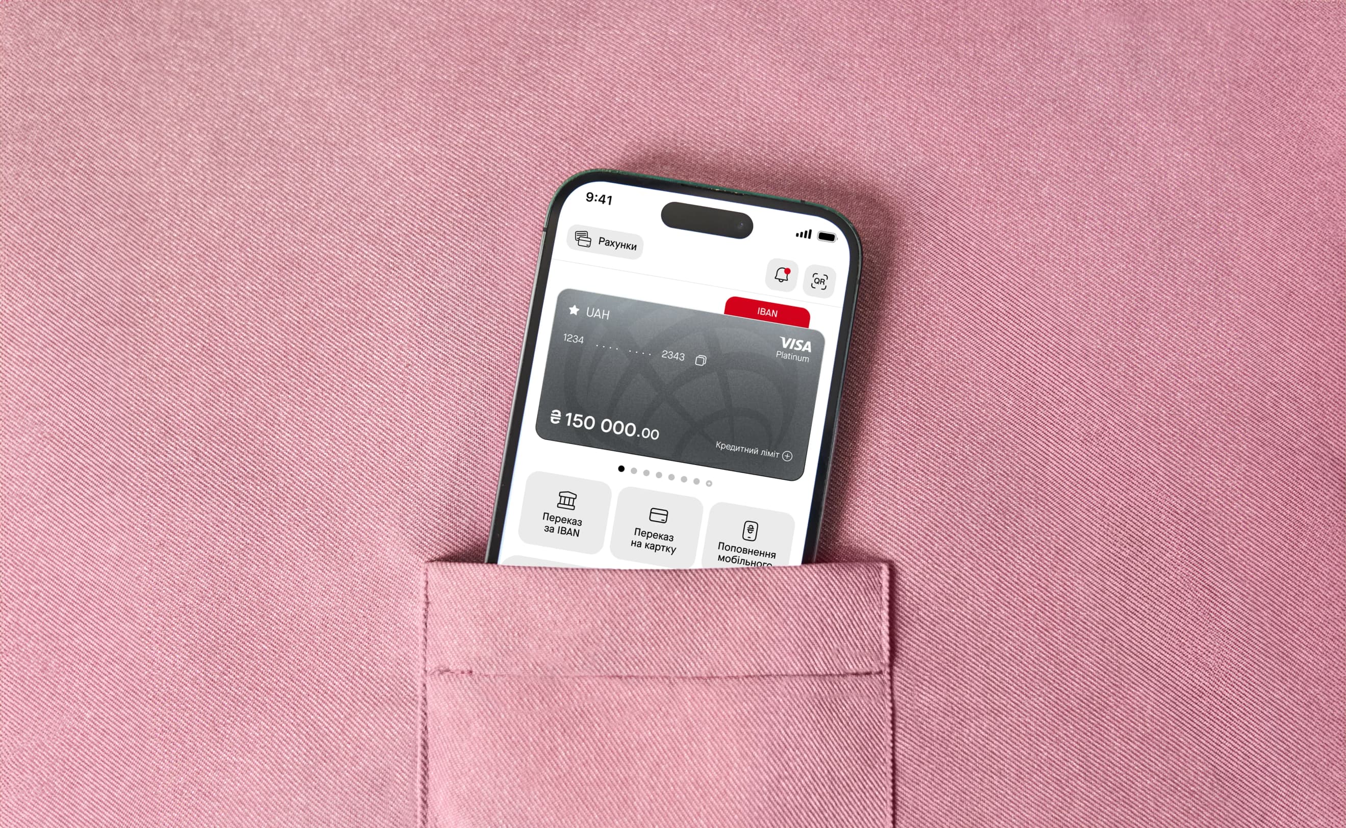 Смартфон із відкритою головною сторінкою застосунку ProCredit Bank стирчить із кишені рожевої тканини.