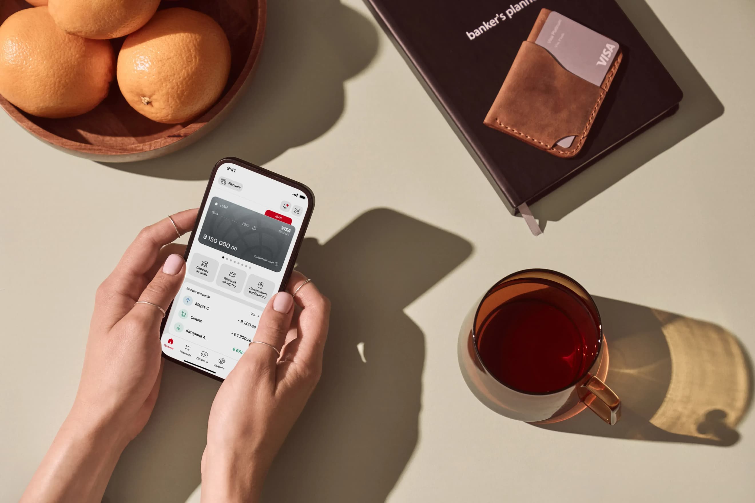 У руках смартфон із відкритим головним екраном мобільного застосунку ПроКредит Банку.