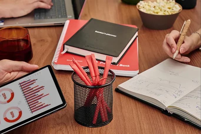 Робочий стіл з ноутбуком, планшетом з графіками, блокнотами, ручками та смартфоном