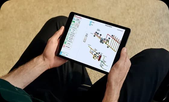 Чоловік тримає планшет в руках і переглядає технічну схема управління будівлею