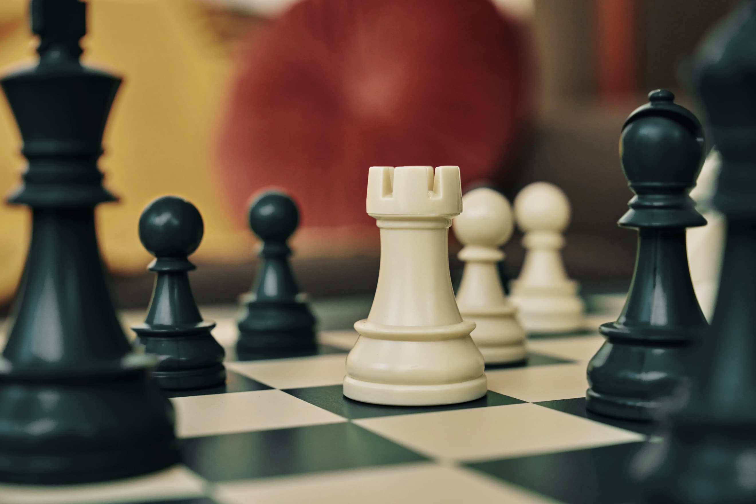 Крупний план білої тури серед інших фігур на шаховій дошці