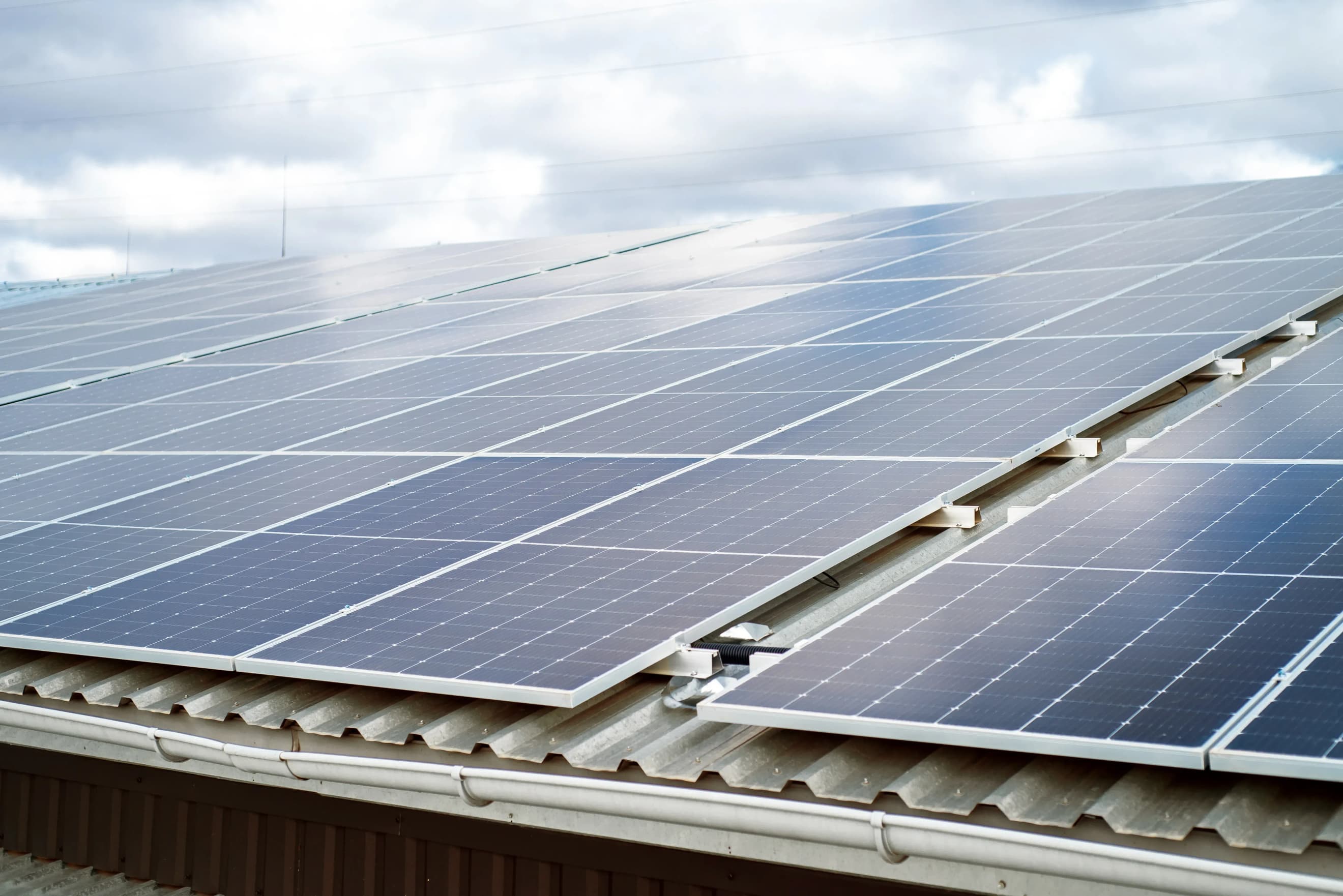 Сонячні панелі встановлені на даху будівлі під хмарним небом